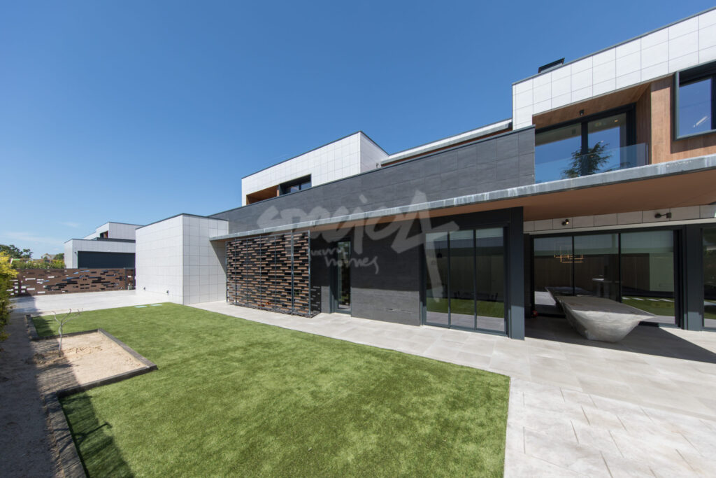 Fachada moderna de vivienda de lujo con jardín, grandes ventanales y arquitectura contemporánea en Franco 72