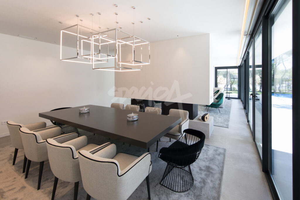 Comedor moderno en vivienda de lujo con iluminación arquitectónica y conexión al exterior en Franco 72