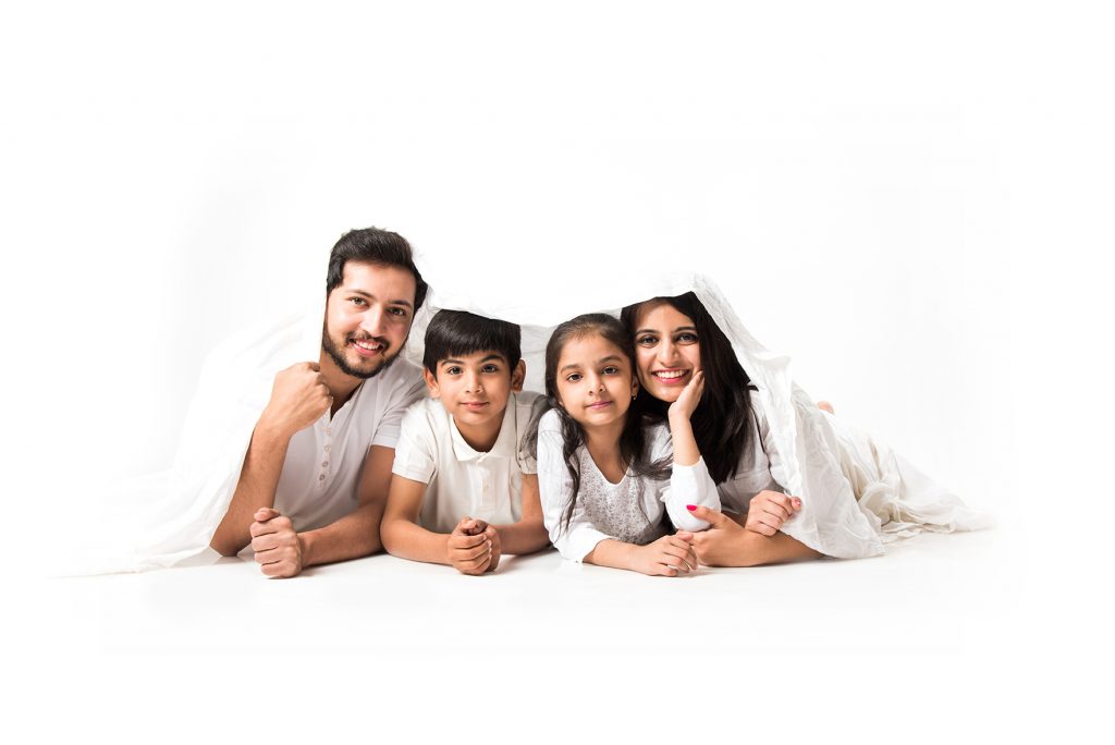 Familia sonriente con dos hijos disfrutando juntos en casa en un ambiente acogedor