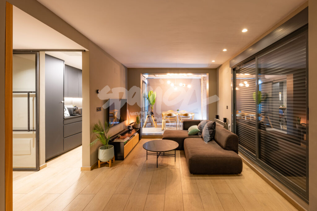 Salón moderno con sofá, zona de estar y comedor integrado en vivienda contemporánea