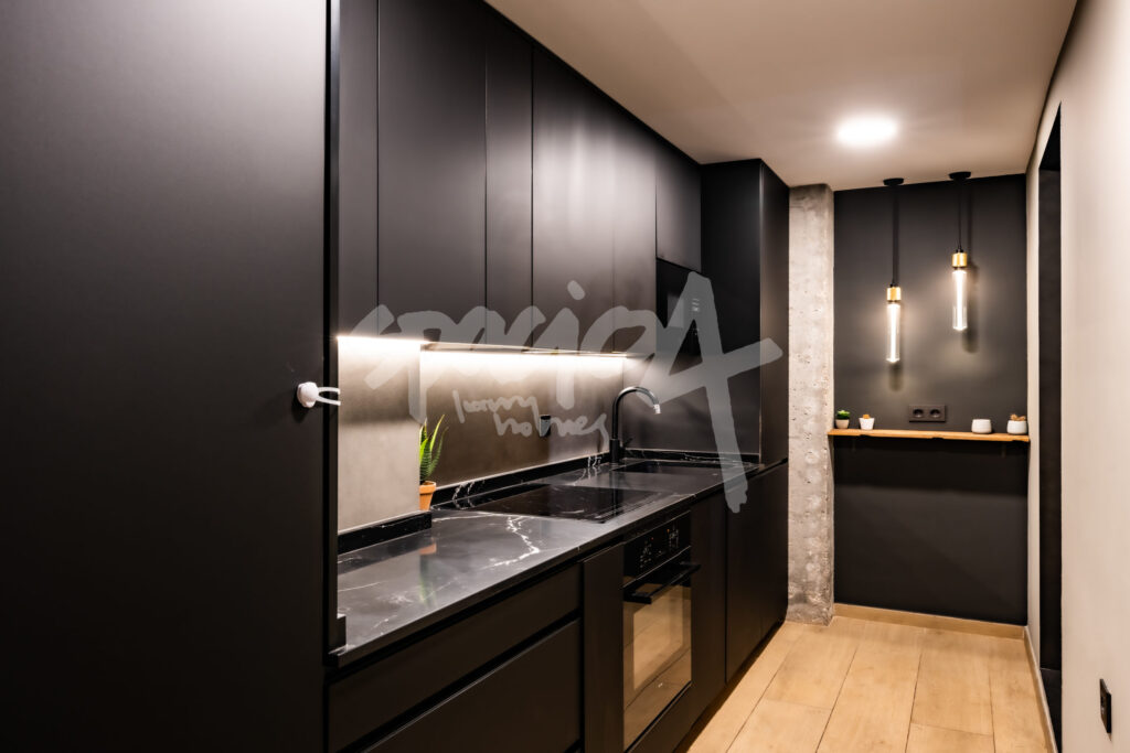 Cocina moderna en color negro con iluminación integrada y diseño actual tendencia 2023