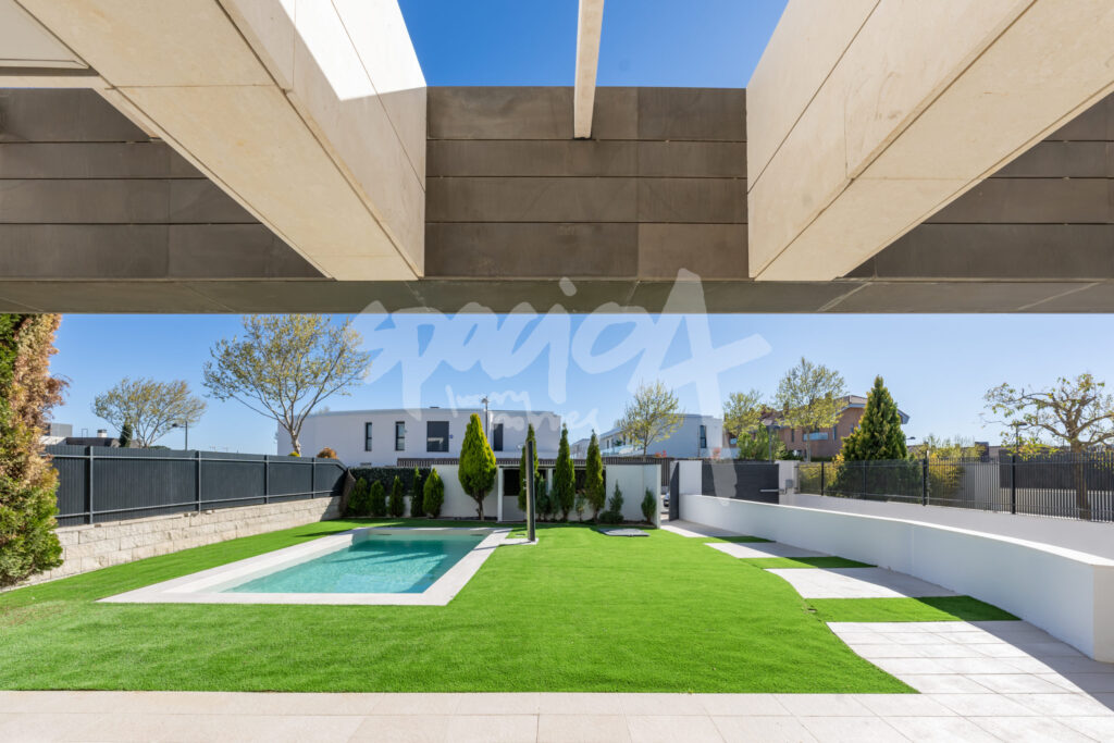 Patio exterior con piscina, césped y arquitectura de estilo mediterráneo moderno