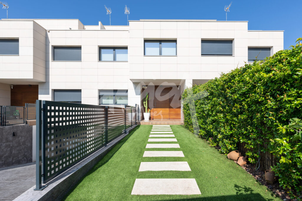 Casa de estilo americano con fachada blanca, jardín delantero y camino de acceso al porche
