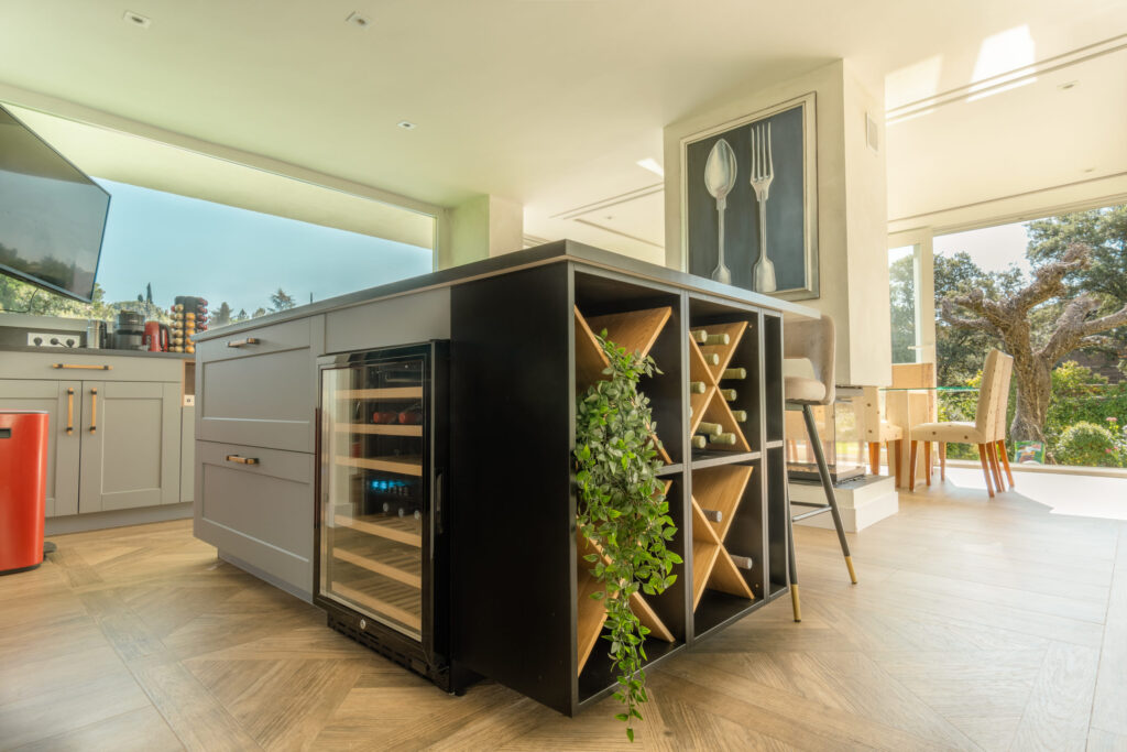 Isla de cocina moderna con vinoteca integrada y almacenamiento para botellas en vivienda de diseño contemporáneo