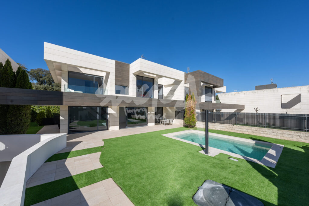 Patio de vivienda unifamiliar moderna con jardín, piscina y arquitectura contemporánea en Madrid