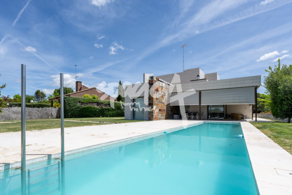 Exterior de vivienda contemporánea con piscina privada, porche cubierto y jardín amplio