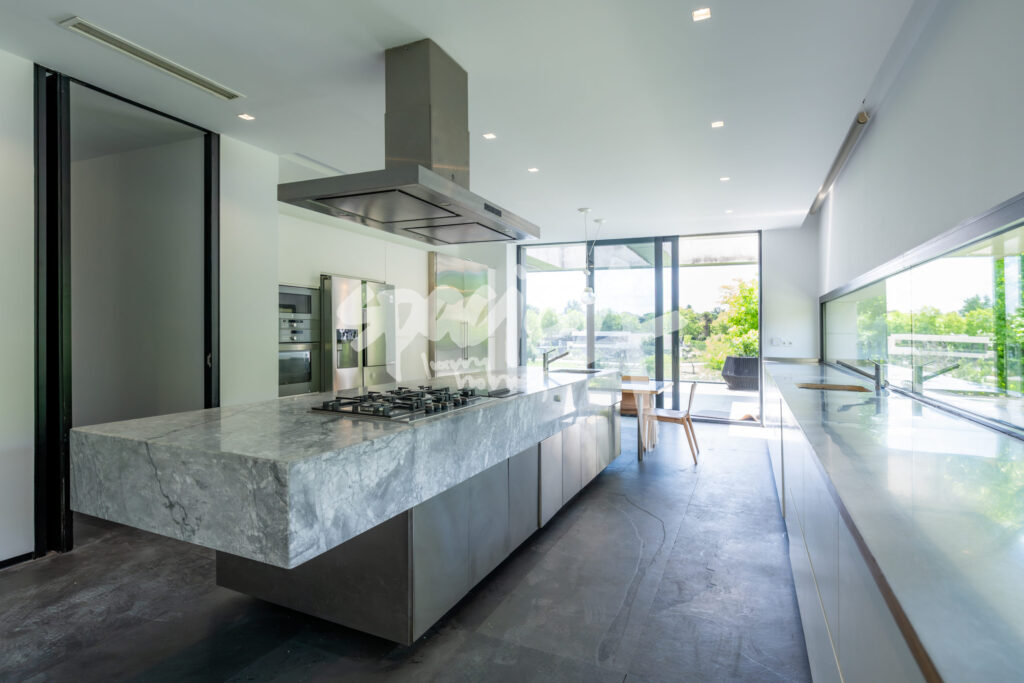 Cocina moderna con isla de mármol, diseño minimalista y grandes ventanales