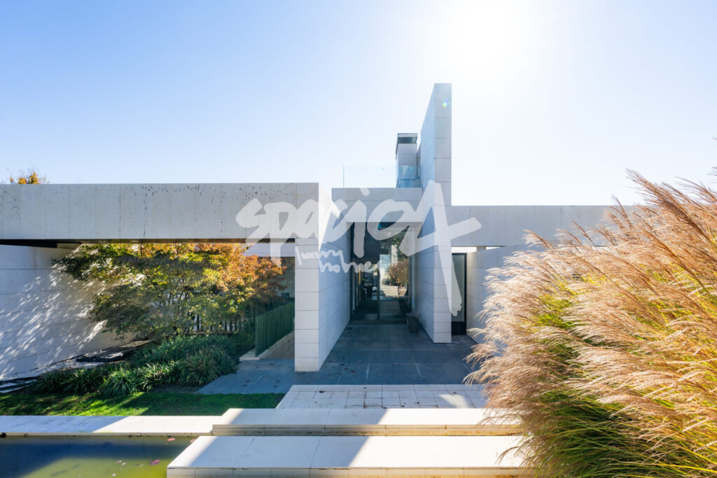 Vivienda moderna en venta con fachada de líneas rectas, jardín paisajístico y acceso arquitectónico de diseño