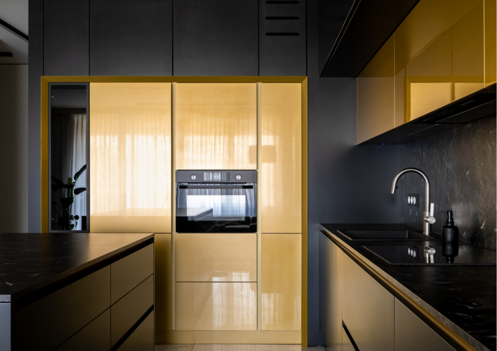 Cocina moderna de diseño con mobiliario en tonos negros y dorados y encimera oscura