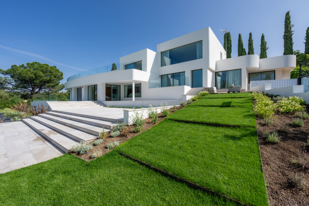 Vivienda contemporánea con amplios ventanales, jardín en pendiente y arquitectura moderna en Valle del Tena