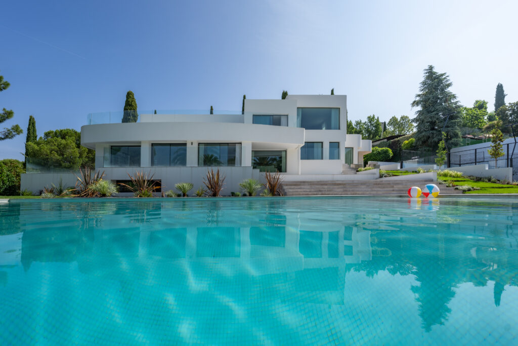 Villa de lujo con piscina exterior y diseño arquitectónico contemporáneo de líneas curvas y grandes ventanales